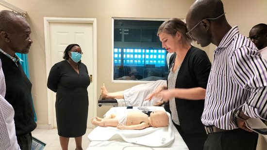 Colleen Fant discussing a simulation with other doctors in Kenya